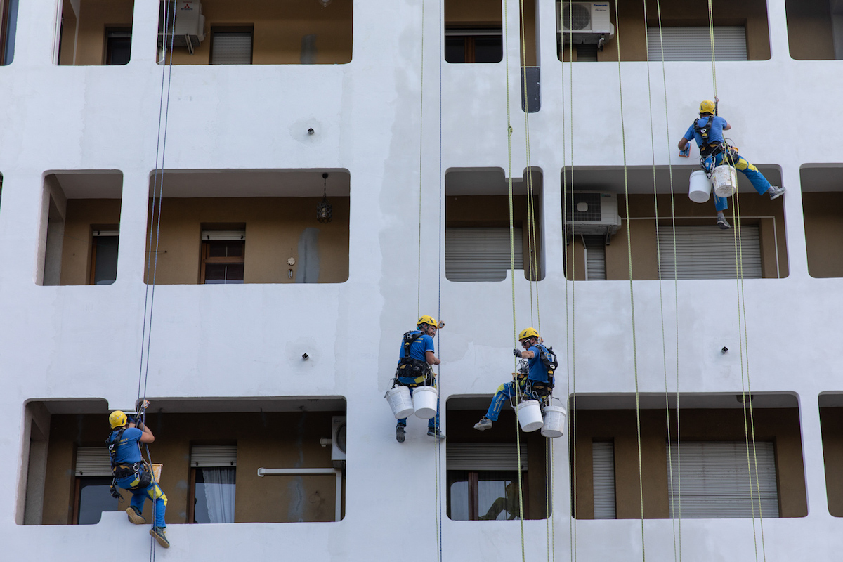 Ouvriers sur cordes devant le bâtiment lors de la rénovation d'une façade