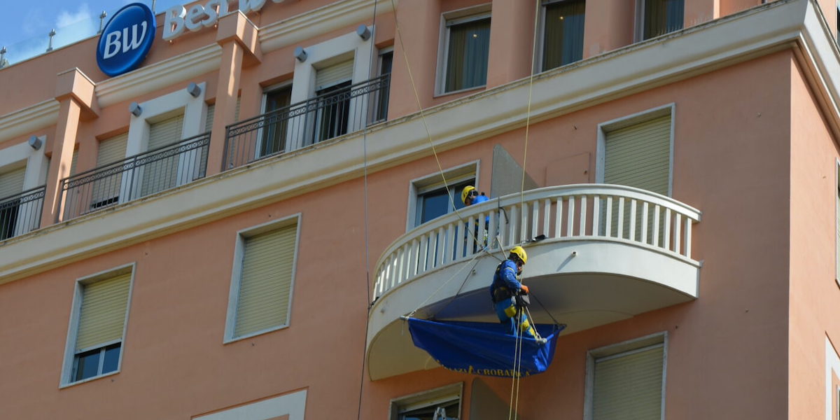 Deux ouvriers d'Acrobatica travaillant sur la terrasse d'un hôtel.