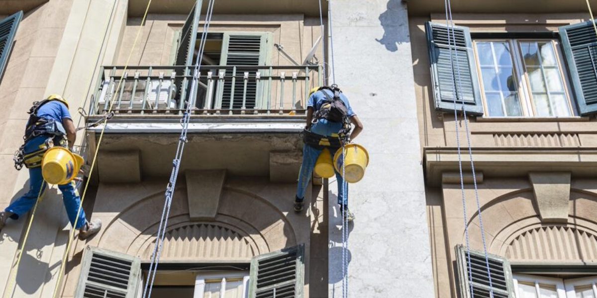 Deux ouvriers d'Acrobatica réalisant la fermeture terrasse en copropriété