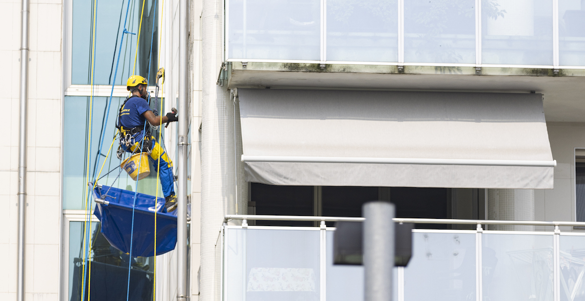 Ouvrier d'Acrobatica sur une corde lors d'un travail de rénovation de façade