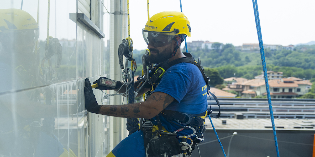 Ouvrier d'Acrobatica lors d'une finition de façade grâce aux "aides pour ravalement de façade"