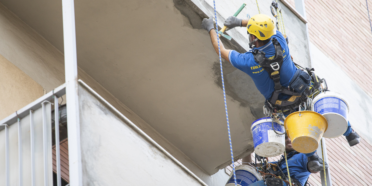 ouvrier acrobatique lors de travaux de rénovation sur un balcon