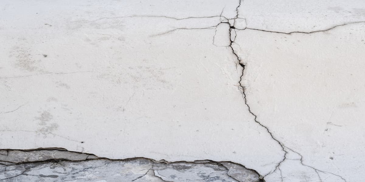 Petite fissure sur un mur blanc, la peinture se décolle