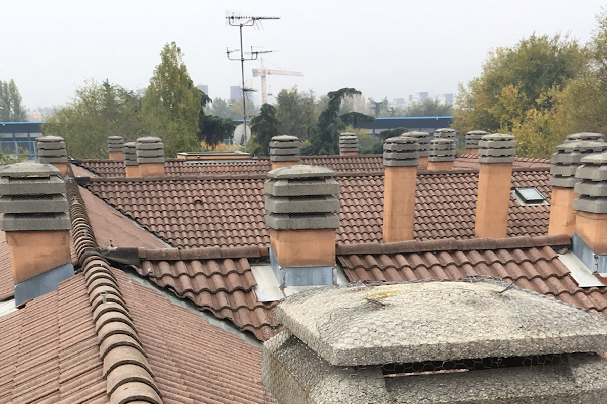 Vue de toits en enfilade avec plusieurs cheminées visibles au sommet des bâtiments
